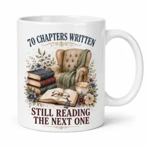 White ceramic 70th birthday book lover mug with 70 Chapters Written Still Reading The Next One reading nook artwork.