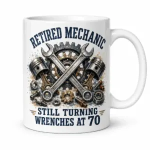 White ceramic mug close-up with Retired Mechanic text, crossed wrenches, gears, pistons, and Still Turning Wrenches at 70 slogan